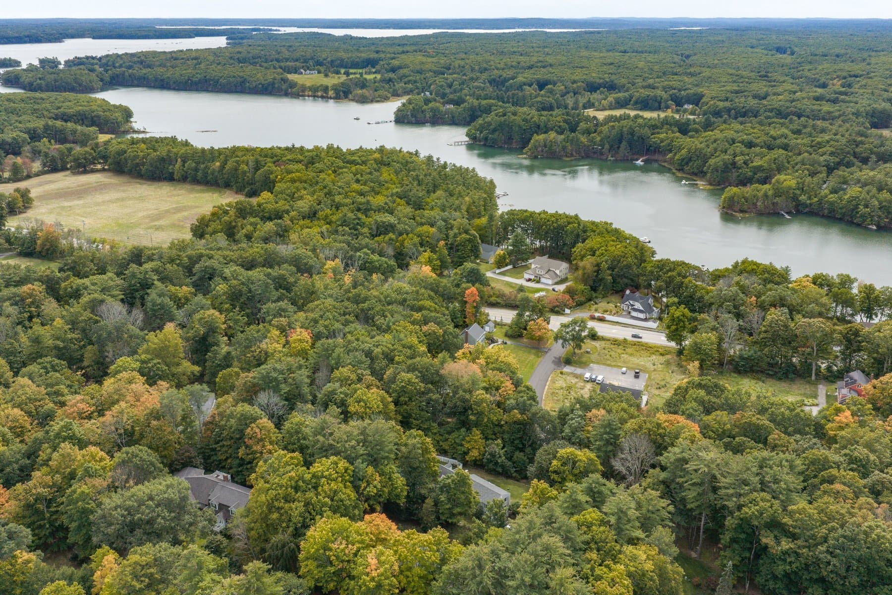 The neighborhood from the air with the bay and its wooded shoreline beyond