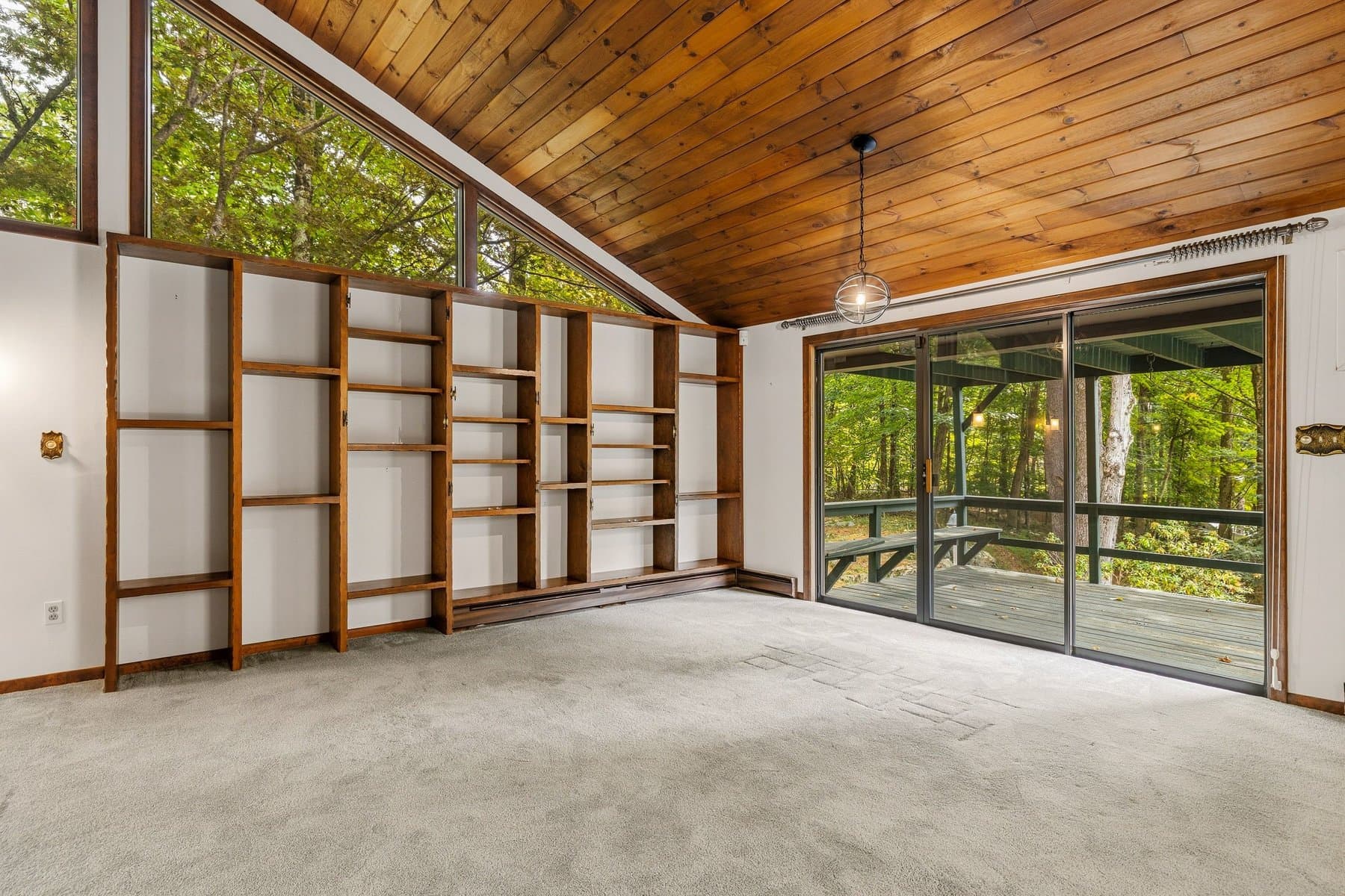 The wood built-in shelving along the living room wall, with the slider to the deck at the end