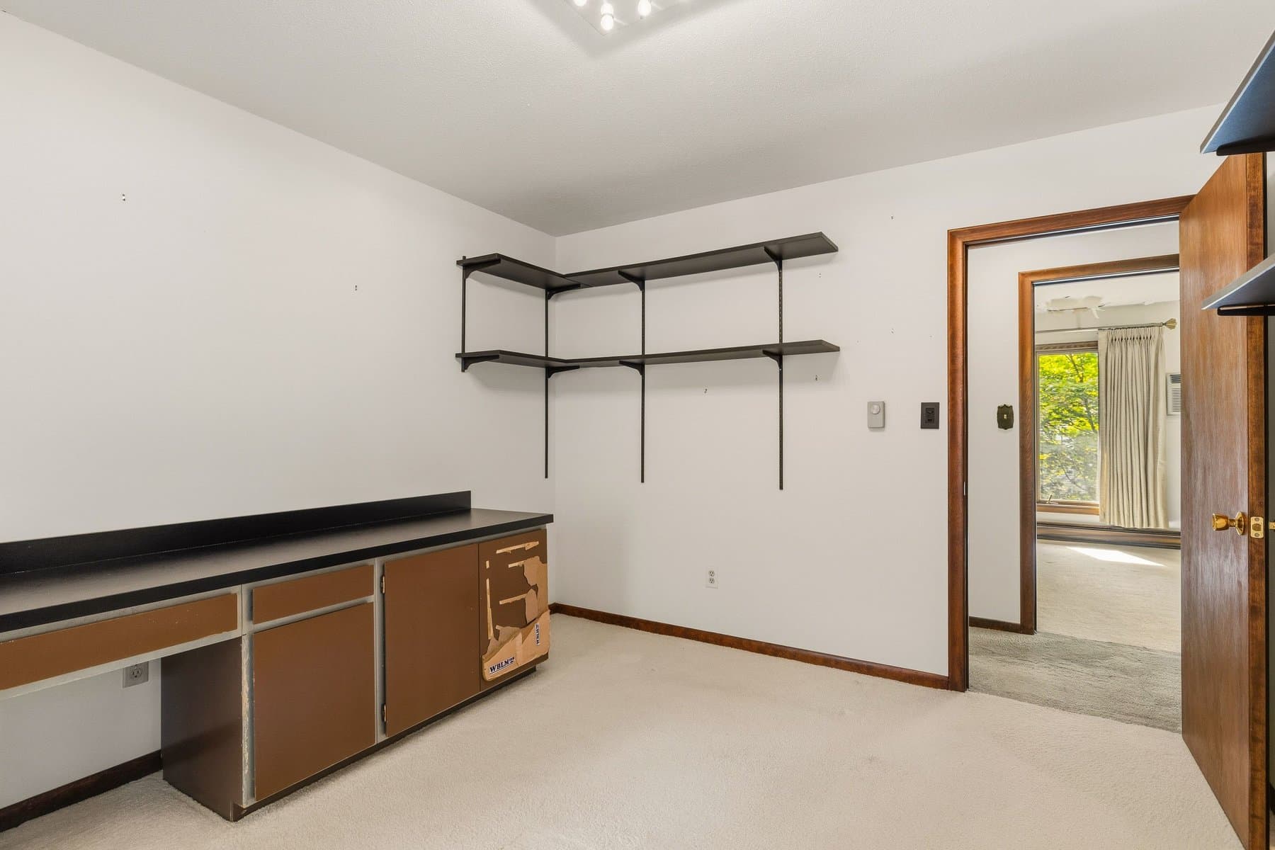 The second bedroom's built-in desk and shelves, with the door open to the living room